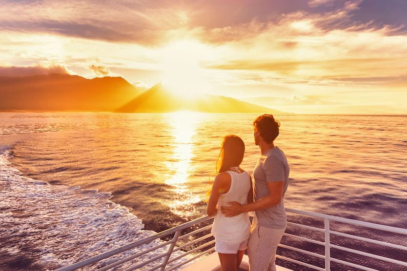 Couple standing AFT on a yacht, looking at the water. Couple standing AFT on a yacht, looking at the water.