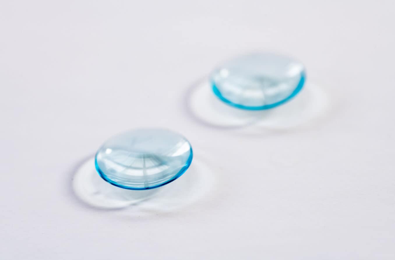 Woman placing contact lens on eye